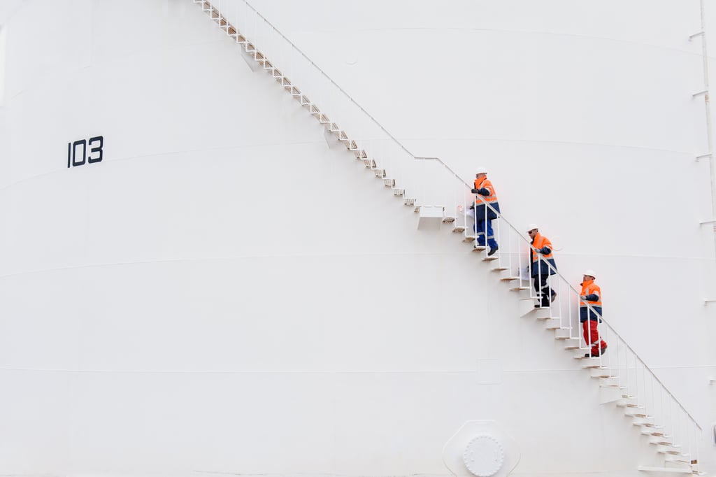 People in construction gear climbing up a ladder